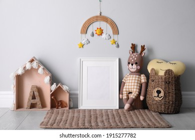 Empty Photo Frame And Cute Toys Near Wall In Baby Room. Interior Design