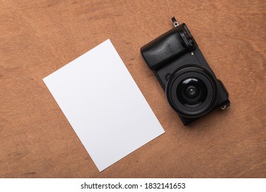 empty photo frames with camera on brown wooden background
