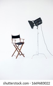 Empty Photo Studio With Lighting Equipment. Space For Text. Vacant Directors Chair. The Concept Of Selection And Casting. Job Recruitment Advertisement.