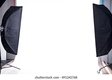 Empty Photo Studio With Lighting Equipment And White Paper Background Ready For Photoshoot