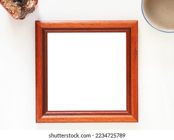 Empty picture frame wooden square shape with coffe cup, and cactus on a white background. Anniversary, valentine, wedding, and mother day concept. Top view, photo frame for template.
