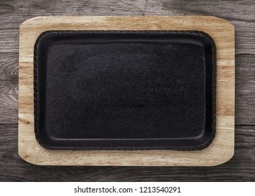 Empty Pig-iron Baking Sheet On A Wooden Support. Food Background