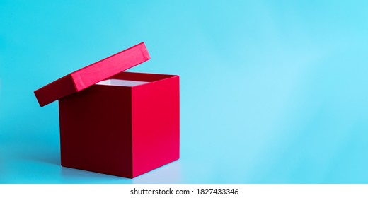 Empty pink gift box with ajar lid on light blue background. Holidays concept. Copy space. Banner. Mockup for branding