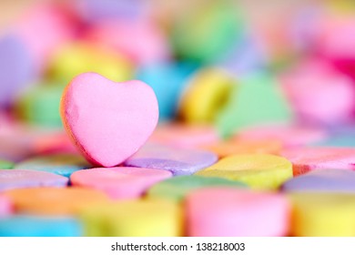 Empty pink heart candy over colorful bonbon