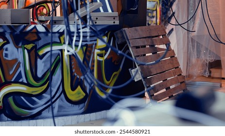 Empty pizza boxes in damaged abandoned warehouse with graffiti drawings on walls. Electric cables hanging in underground location used as crime haven by delinquents, urban background - Powered by Shutterstock