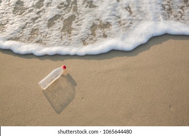 Empty Plastic Bottle On Sea Beach, Environmental Or Polution Concept