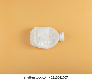 Empty Plastic Milk Bottle Isolated, Crumpled Plastic Bottle, Global Pollution Concept, Squashed Pet Bottles on Yellow Background