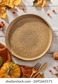 Empty plate and autumn elements, view from above