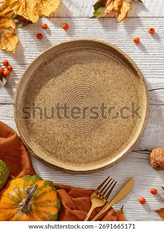 Empty plate and autumn elements, view from above