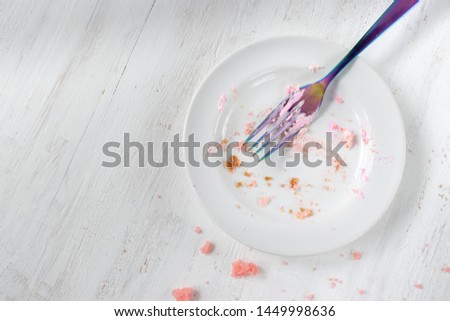 empty plate of birthday cake crumbs with fork flat lay