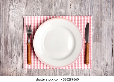 Empty Plate And Cutlery On The Wooden Table