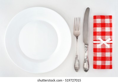 Empty Plate With Cutlery And Red Checkered Napkin. Overhead View.