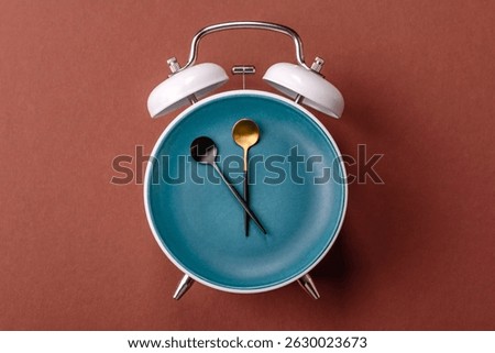 Empty plate with devices in the form of clock hands as a conceptual background for lunch time, coffee break, meal