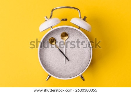 Empty plate with devices in the form of clock hands as a conceptual background for lunch time, coffee break, meal