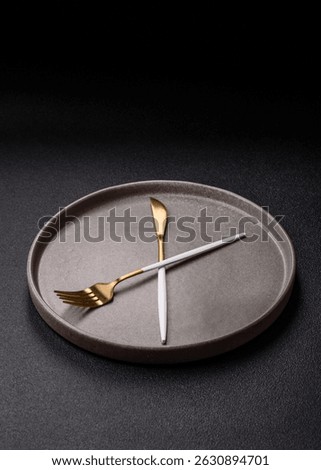 Empty plate with devices in the form of clock hands as a conceptual background for lunch time, coffee break, meal