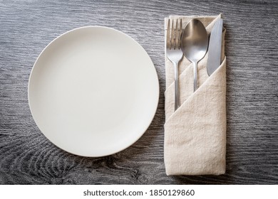 Empty Plate Or Dish With Knife, Fork And Spoon On Wood Tile Background