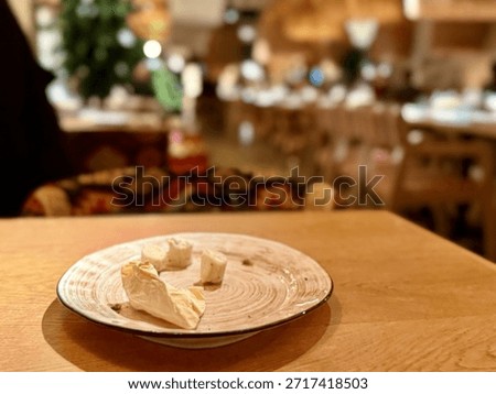 Empty Plate With Dumpling Remnants And Crumbs, Casual Dining Aftermath On Wooden Table, Tiny Scraps Of Dough And Napkin Pieces Suggest Satisfied Diner, Warm Lighting And Rustic Dishware