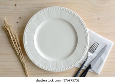 Empty plate with knife and fork on old wooden background, Top view - Powered by Shutterstock