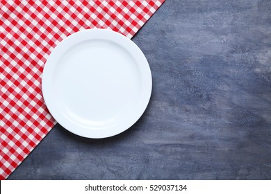 Empty plate with napkin on grey wooden table