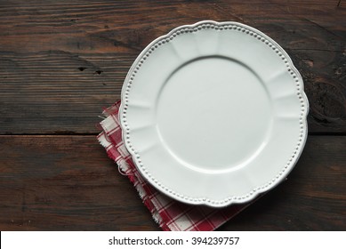 Empty Plate And Napkin On A Wooden Background Of A Table. Top View