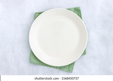 Empty Plate On Grey Stone Table And Napkin. Food Background For Menu, Recipe. Table Setting. Flatlay, Top View. Mockup For Restaurant Dish