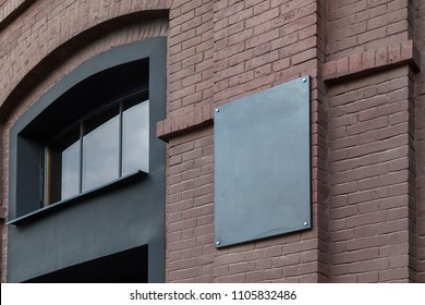 An Empty Plate On An Old Building Of A Dark Brick Factory. Mockup.