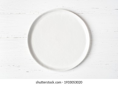 An Empty Plate On A White Wooden Table. Top View.