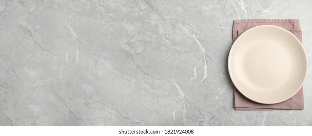 Empty Plate And Pink Towel On Light Grey Marble Table, Top View. Space For Text