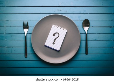 Empty Plate With A Question Mark Drawn On A Notepad On A Blue Table, Food Concept