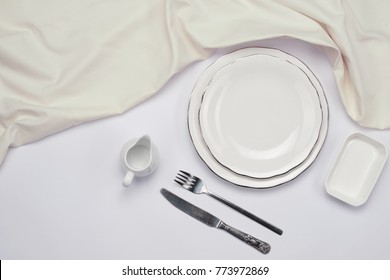 Empty plate and silverware set on wooden table. Top view.