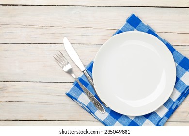 Empty plate, silverware and towel over wooden table background. View from above with copy space - Powered by Shutterstock