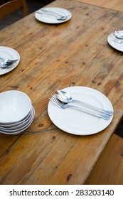Empty plate with spoon and fork on wooden background