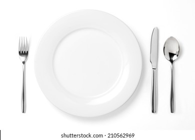 Empty Plate With Spoon, Knife And Fork On A White Background.