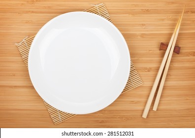 Empty Plate And Sushi Chopsticks On Bamboo Table