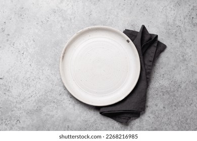 Empty plate and towel on stone kitchen table. Flat lay with copy space - Powered by Shutterstock