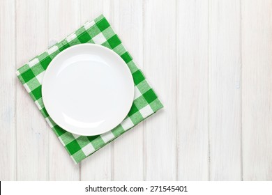 Empty Plate And Towel Over Wooden Table Background. View From Above With Copy Space  