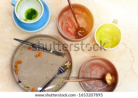 empty plates and cups after eating, waste food after raw healthy breakfast on the table. glare, flare