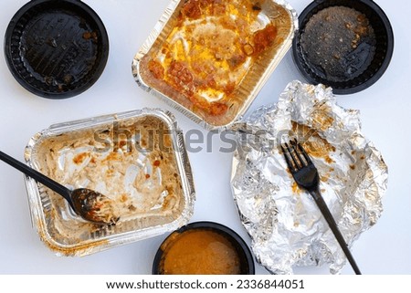 empty plates with forks, sauces and aluminum bowls top view. Used plastic dishes are dirty after eating. Home delivery Mexican food. Dirty disposable tableware after a meal top view