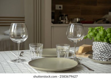 empty plates on the table, spring cozy home table setting with glasses and fresh basil on light tablecloth. Top view, copy space. background for menu - Powered by Shutterstock - Get 15% off with code: PIKWIZARD15