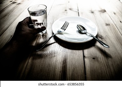 Empty plate,Water glass,fork and spoon on the dark old wood background.black and white tone