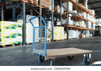 Empty platform hand truck standing in warehouse of construction hypermarket or garden store ready to transport goods