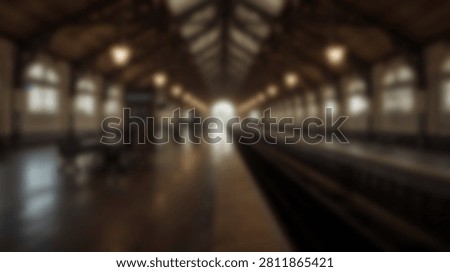 An empty platform inside a vintage train station, featuring an arched ceiling, large windows, and warm lighting.