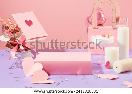 An empty podium is placed in the center of the frame, next to it are cards, paper hearts, chocolates, candles, gift bags and cocktail glasses. Copy space for ads.