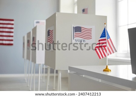 Empty polling station with row of white voting booths decorated with American flag at vote center. Presidential American elections in the United States. Democracy and election day concept.