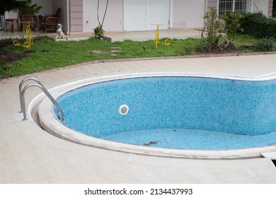 An Empty Pool In The Backyard Of The House.