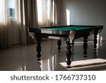 Empty pool table in the sunlight. Pool table in an empty room lit by sunlight.