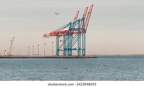 Empty port berth with two gantry cranes. Sunset at empty container terminal - no ships today.   - Powered by Shutterstock