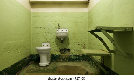 An empty prison cell at Alcatraz National Park with hideous institutional green paint.