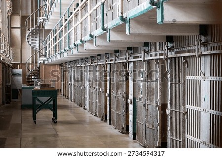 Empty prison cell block corridor with metal doors