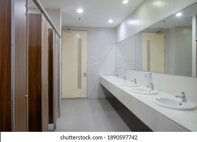 Empty public bathroom with lavatory and wide wall mirror, concept for public toilets. - Shutterstock ID 1890597742